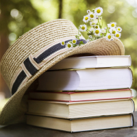 a straw hat sitting next to a stack of books