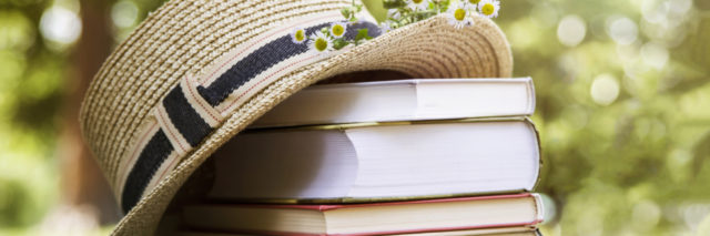a straw hat sitting next to a stack of books