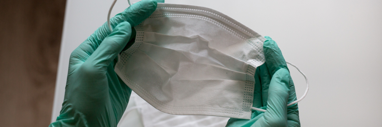 How COVID-19 Safety Rules Impact Blind Accessibility Two hands wearing medical gloves holding a mask.