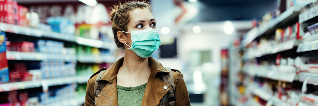 What It's Like to Have Harm OCD During COVID-19 A young woman walking down the isle in a grocery stories with her mask on