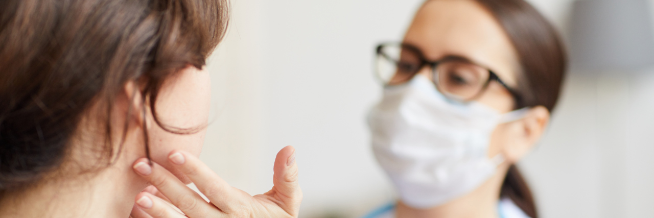 Doctor's Appointments: What to Expect During COVID-19 young woman being examined by a doctor wearing a mask and glasses