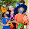 Kids trick or treat in Halloween costume and face mask.