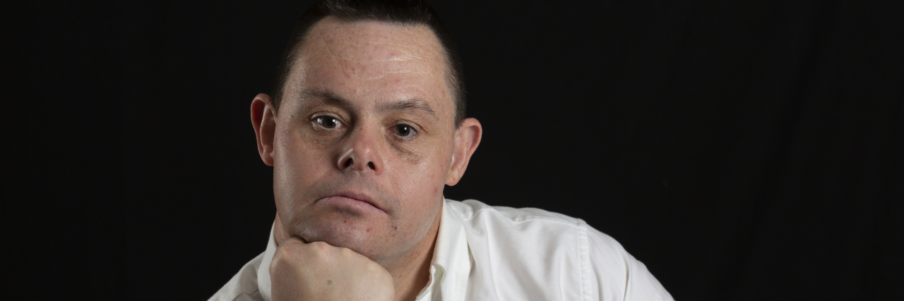 New Clinical Guidelines Established for Adults with Down Syndrome man with down syndrome in photo studio on black background