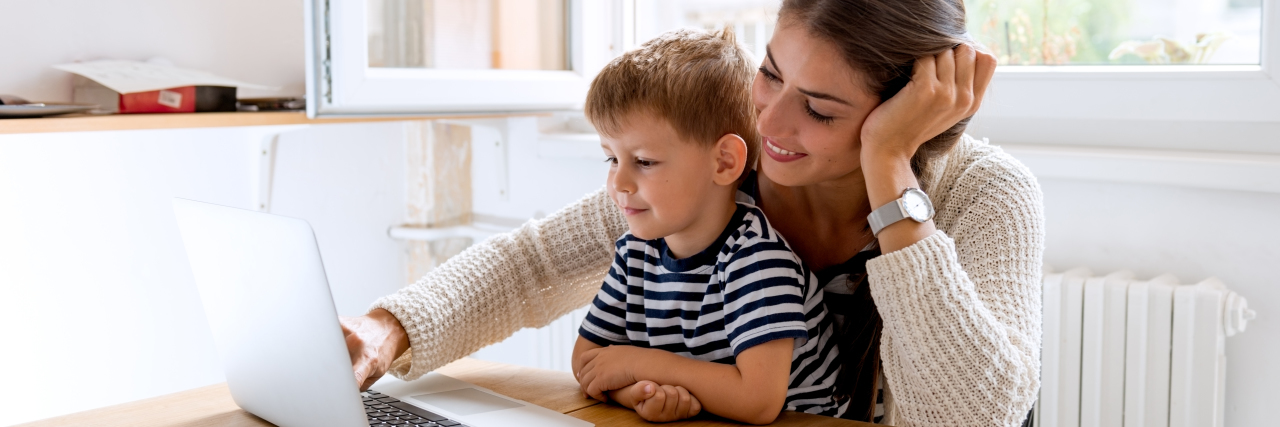Navigating IEP Season During COVID-19 and Beyond Mother helping son use computer.