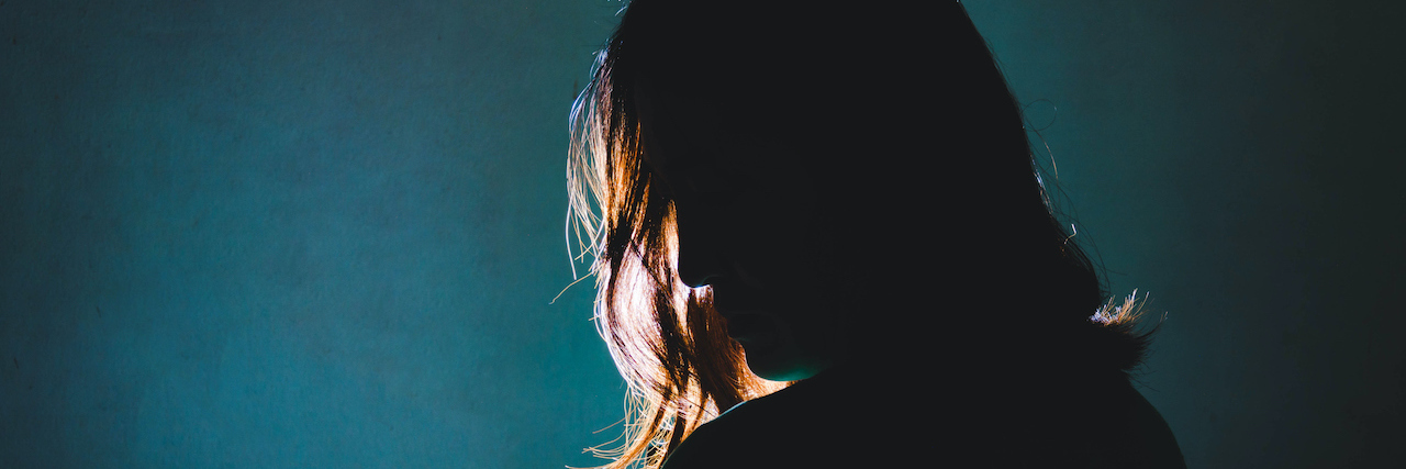 Moving Through Depression and Towards Hope Silhouette of woman standing in the dark with light shining behind