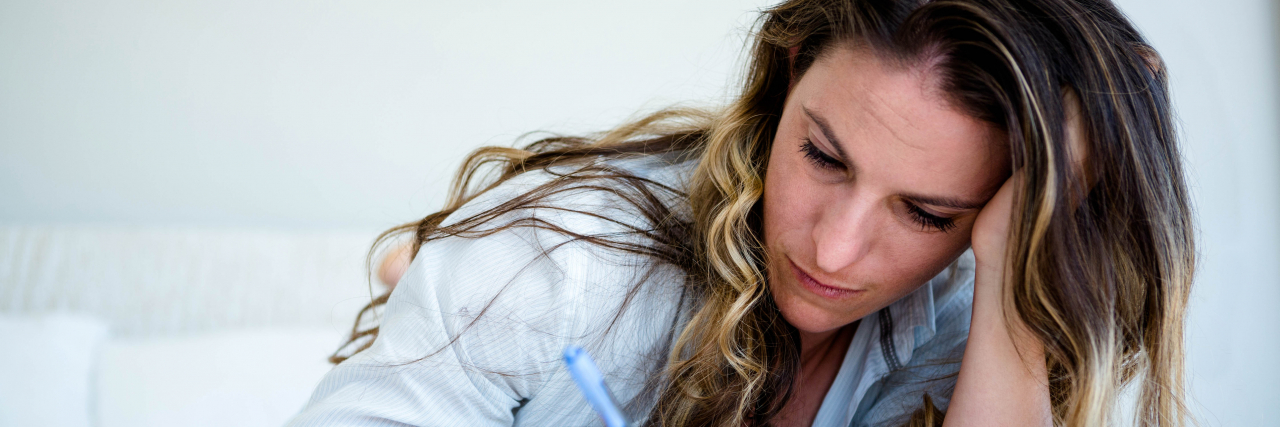 The Things I Forgot to Tell You About My Chronic Illness a woman lying down writing in a book