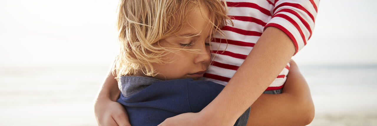 My Biggest Fear as the Parent of a Child With a Rare, Terminal Disease Mother hugging son on the beach.