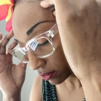 a woman with glasses with her hands on her temples
