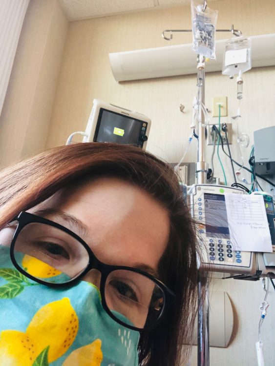 The author in a hospital room wearing a mask and glasses.