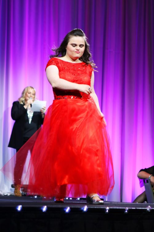 Rachel on stage in a red dress.