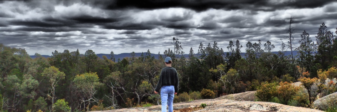 Why You Should Never Say 'Your Pain is Nothing Compared to Mine' Woman looking at a stormy sky.