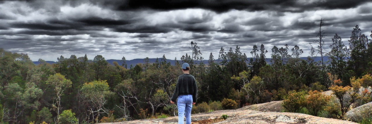 Woman looking at a stormy sky.