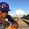 Anthony Galindo Ibarra wears a ball cap and poses in front of train tracks