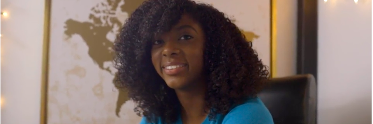 Hannah Lucas, a teen with black natural hair wearing a blue and white T-shirt
