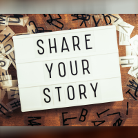 Share Your Story text on the lightbox with plastic alphabets scattered on wood background