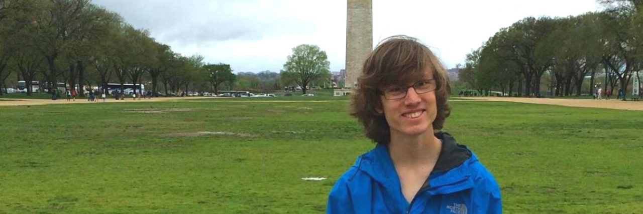About This Photo of Myself as a Teenage Boy With an Eating Disorder photo of contributor at 15 years old, standing in front of washington monument wearing a blue rain jacket