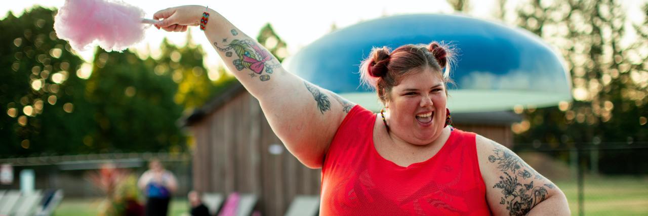 How Dieting Harms Our Mental Health A woman, fat and happy, holding up cotton candy at a pool