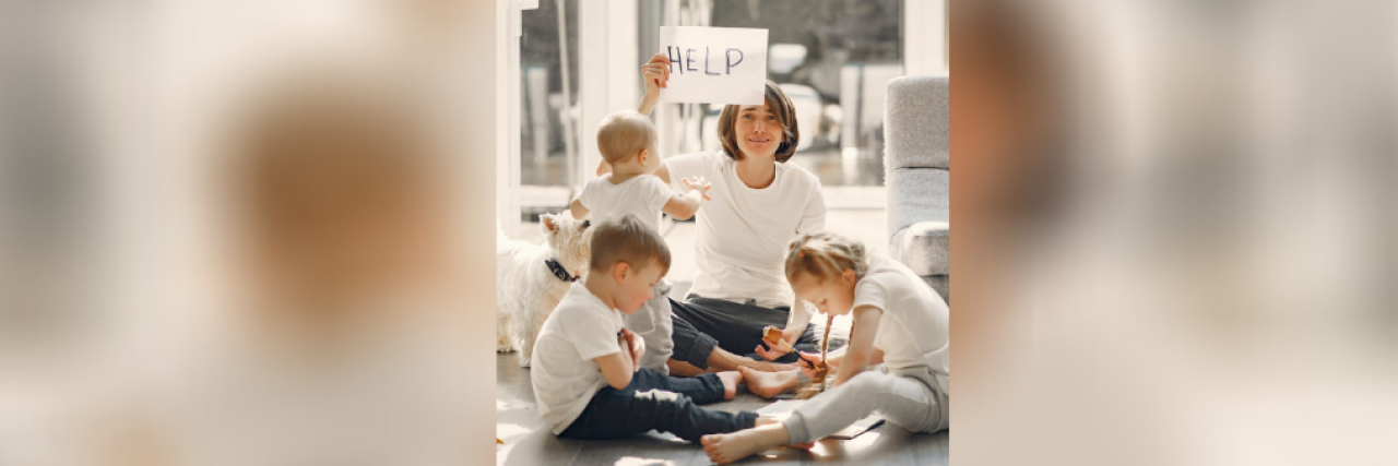 Dealing With Parental Burnout and Overwhelm During COVID-19 Woman with young children holding a sign that says "help"