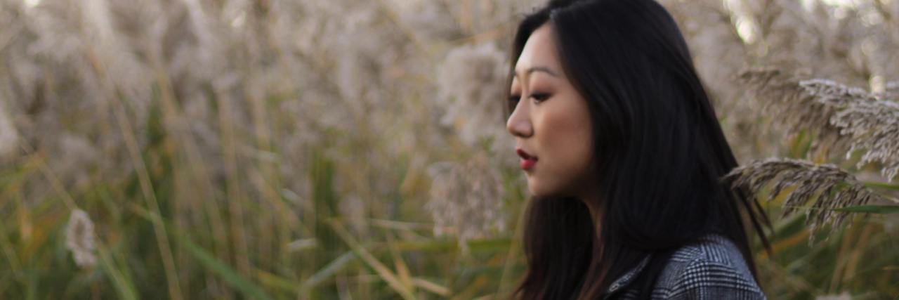 People Don't Know I Have Dissociative Identity Disorder photo of woman standing in profile against long plants