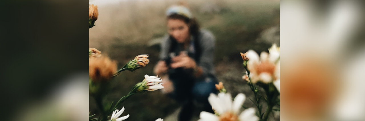 Planning for Your Funeral and Wishes With Stage 4 Colon Cancer Photo of daises in foreground with woman blurred in background