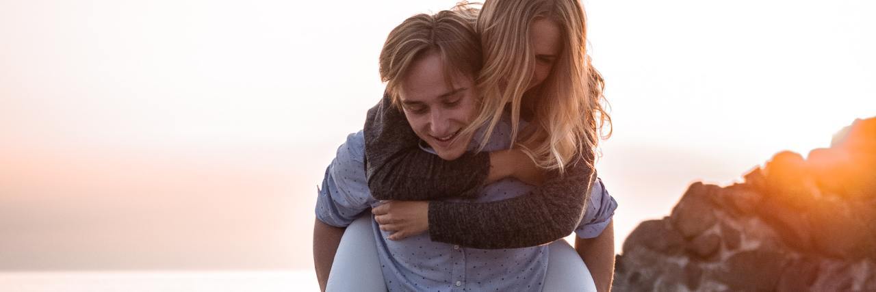 What 'Active Support' for Mental Illness Recovery Means photo of man carrying a woman on his back on a beach at sunset