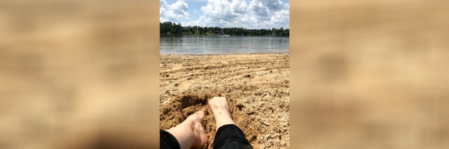 Image of contributor's feet digging into sand on a beach