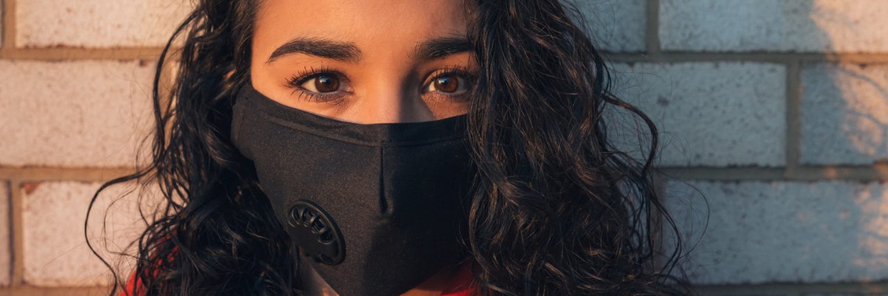 COVID-19: Anxious Leaving the House girl with a mask looking straight at the camera