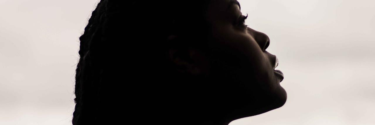 How To Get Involved and Reduce 2020 Election Anxiety photo of a black woman against a cloudy background in silhouette, looking up to sky