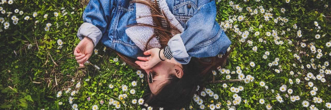 Learning to Live Life to the Fullest Despite My Anxiety Woman laying on grass and flowers
