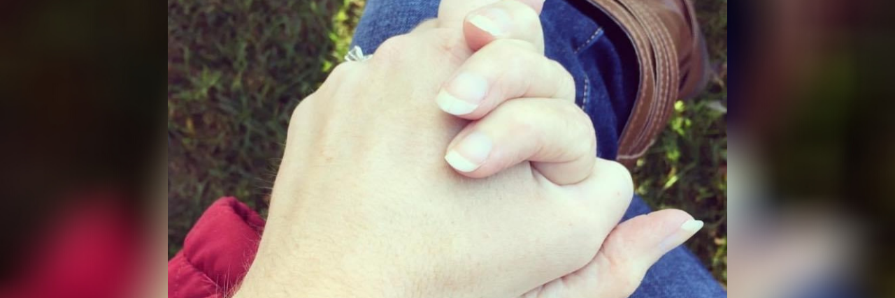 Closeup of Lauren's hand holding her mother's hand.
