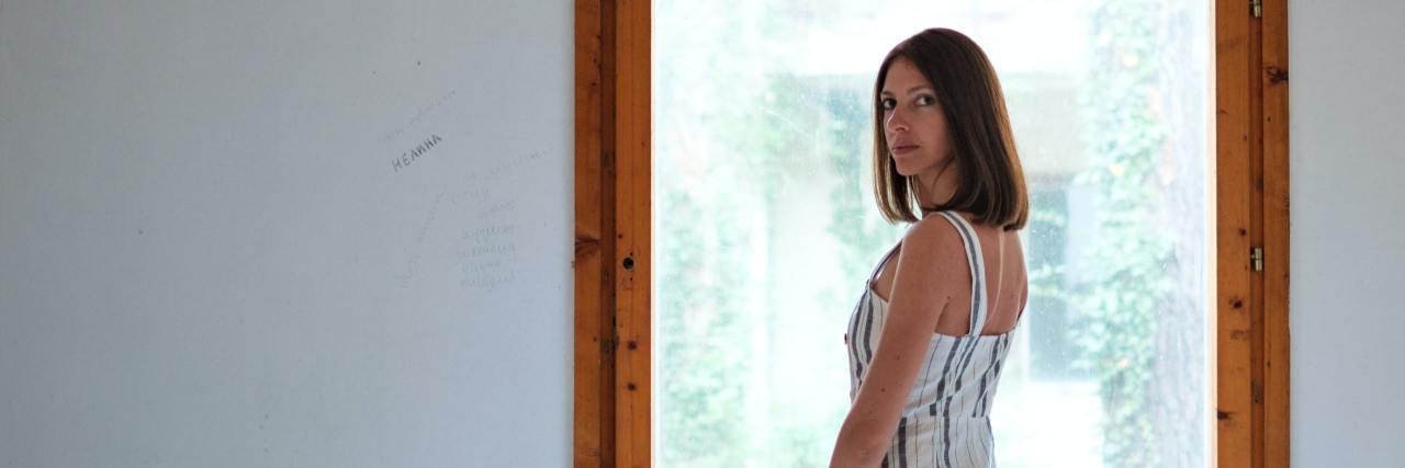 Struggling With Addiction and Anxiety During the Coronavirus Pandemic photo of woman posing in front of large square window