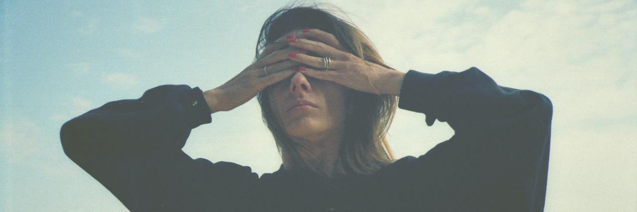Self-Care Tips for Trauma Survivors Struggling During Election Season woman standing with hands over her eyes