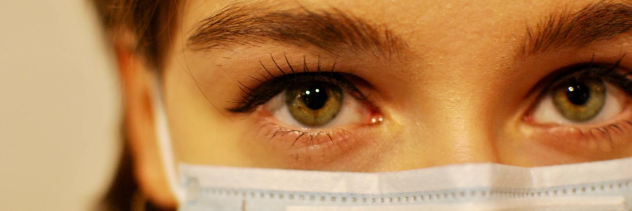 Experiencing Gaslighting When You Wear a COVID-19 Mask photo of woman wearing a mask and looking into camera