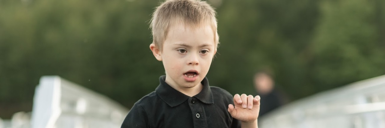 Little boy with Down syndrome running