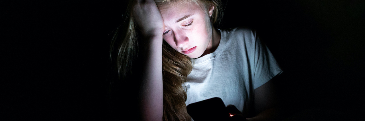 I'm Sorry My Depression Made Me Cancel A sad woman looking at her phone