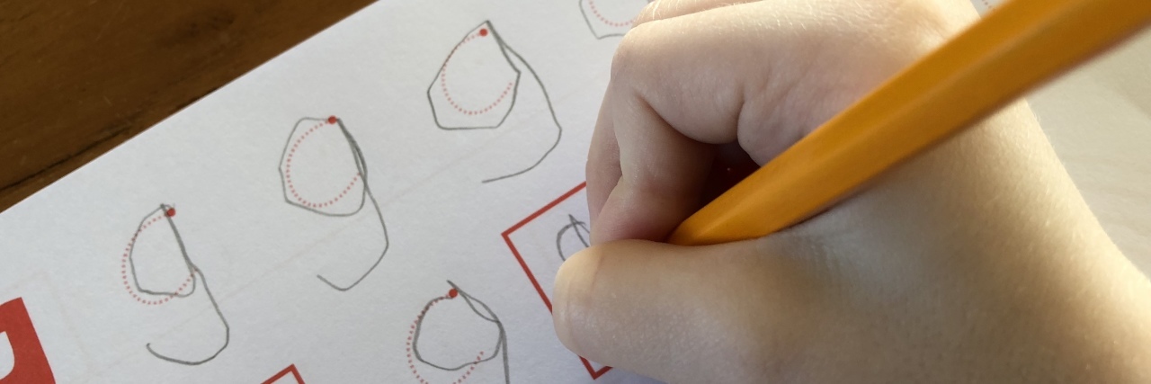 Child practicing writing letters of the alphabet.