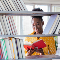 African American college student at library.