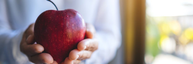 Closeup image of a hands holding a red apple
