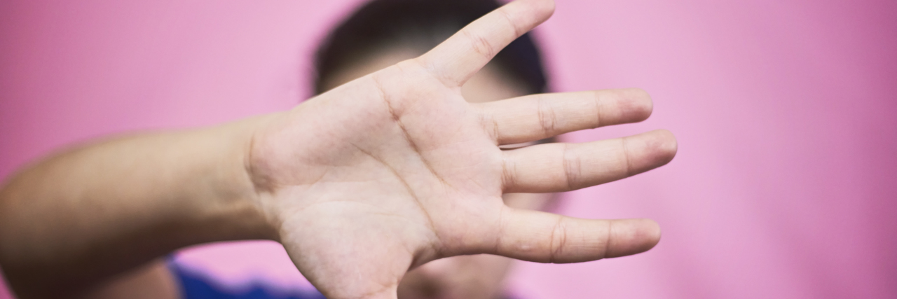 Don't Take Pictures of People With Dwarfism Without Consent Woman blocking her face with her hand.