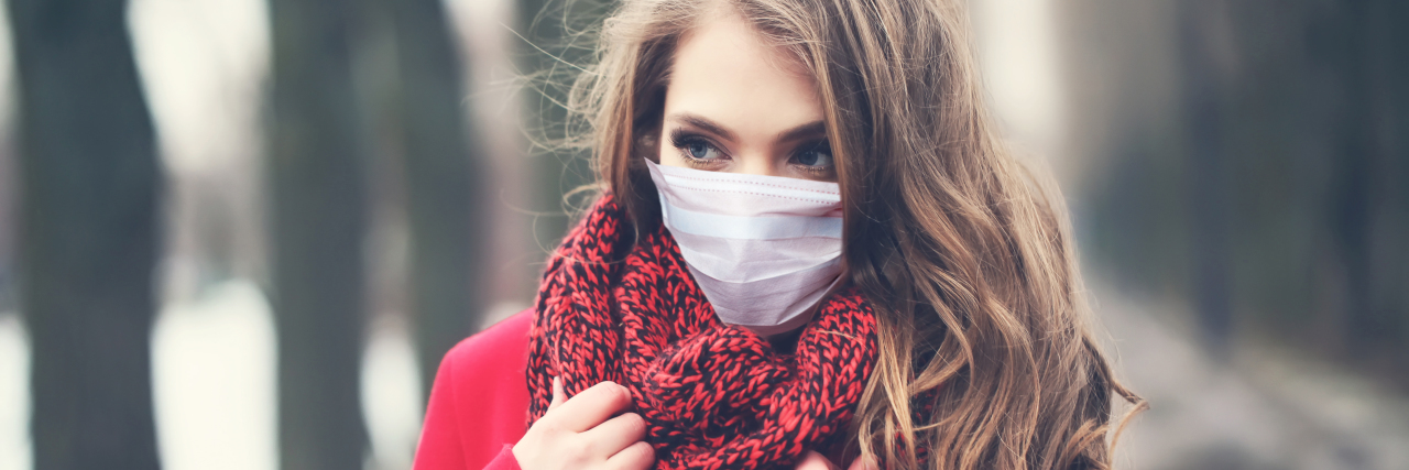 Why It’s Weird Being Chronically Ill During the COVID-19 Pandemic Woman wearing face mask and winter coat.