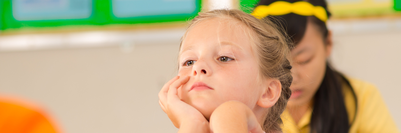 What to Know About ADHD During Learning Disabilities Awareness Month Distracted girl sitting at desk in the classroom.