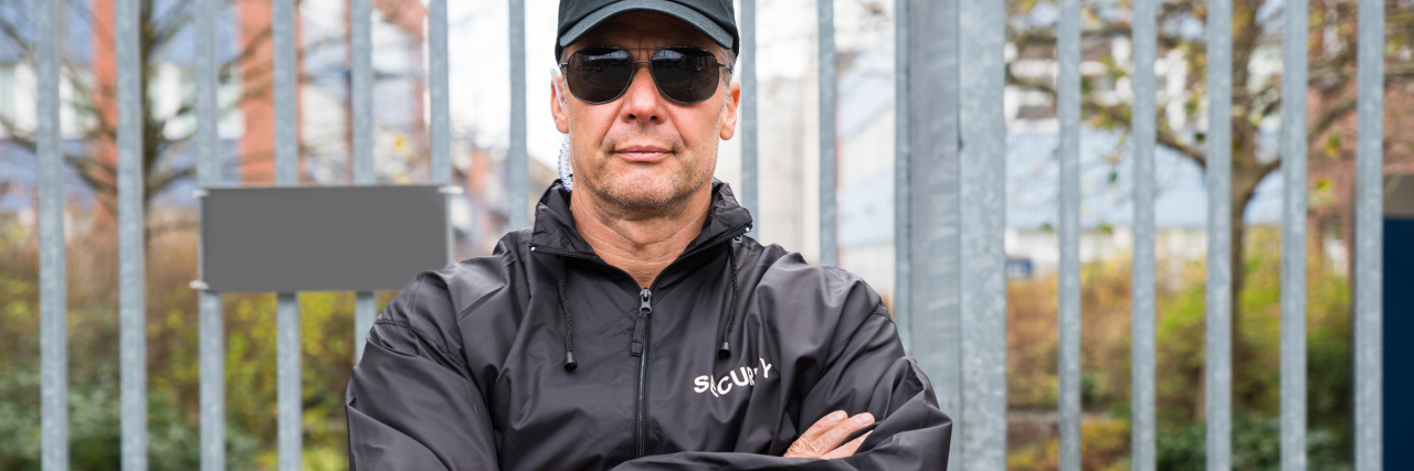 Neurotypical People Need to Stop Gatekeeping Autism Security guard blocking gate.