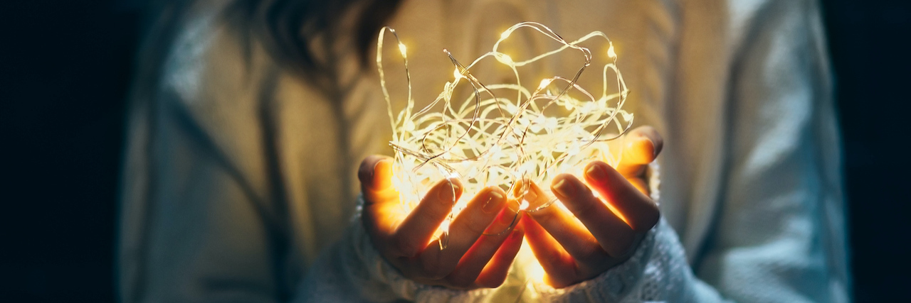 Hanging Up the Christmas Lights After My Husband Died of COVID-19 A woman holding christmas lights in her hands
