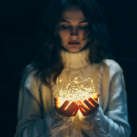 A woman holding christmas lights in her hands