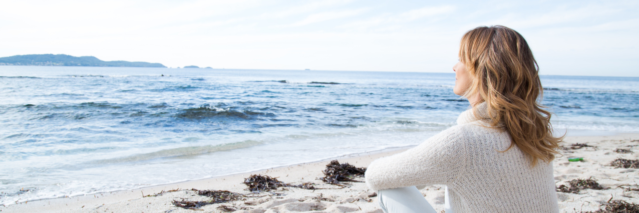 Relieving Stress While Caring for Your Child With a Medical Condition Woman in winter on a beach.