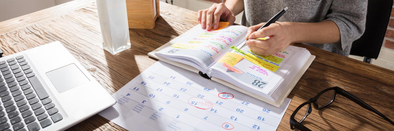 Navigating Triggers: 6 Tips To Prepare to See a New Doctor a woman's hands writing in a daily planner