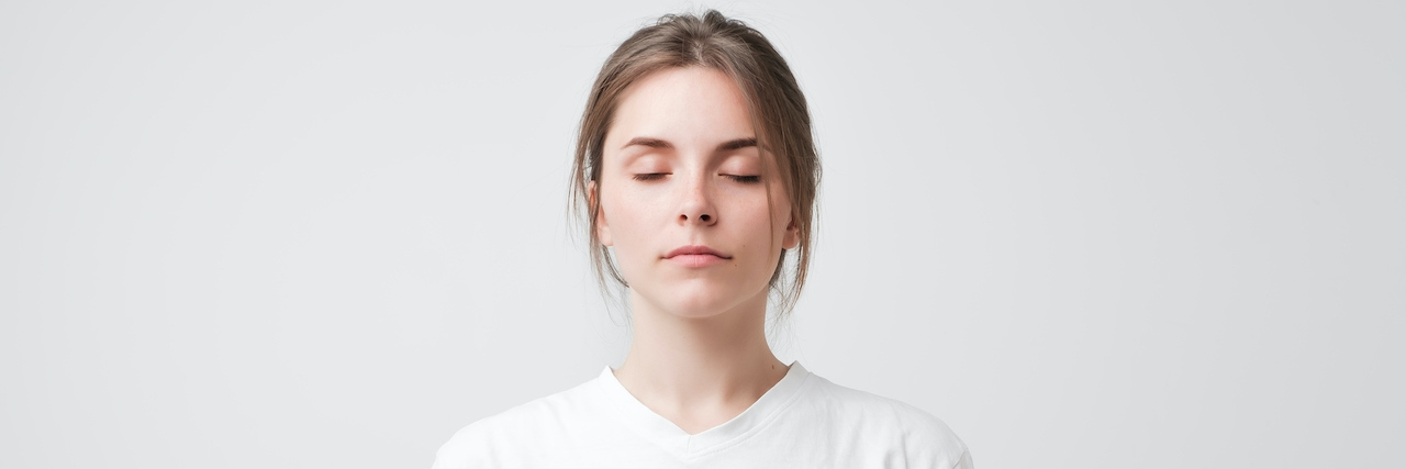 Woman with her eyes closed on a white background