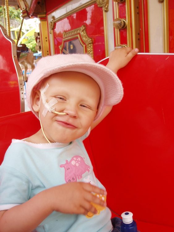 a young girl with feeding tube in her nose smiling