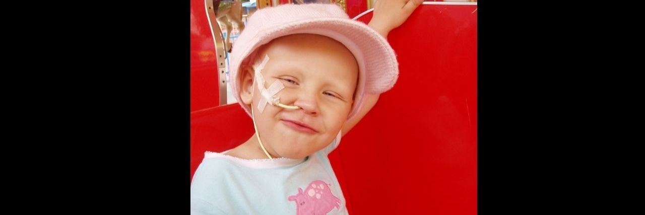 What Grief Taught Me About Resilience a young girl with a feeding tube smiling