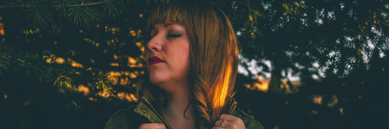 I Can't Trust My Pain or Senses With Central Pain Syndrome woman standing in a forest with her eyes closed and head turned